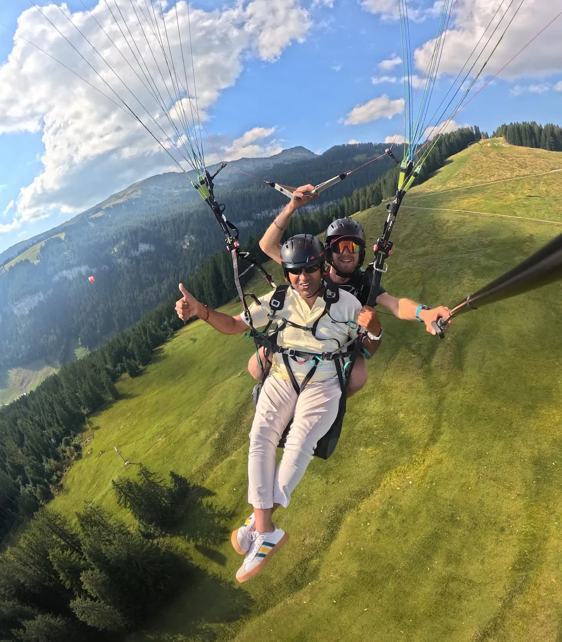 Smiling passenger during a tandem paragliding flight in Valais.